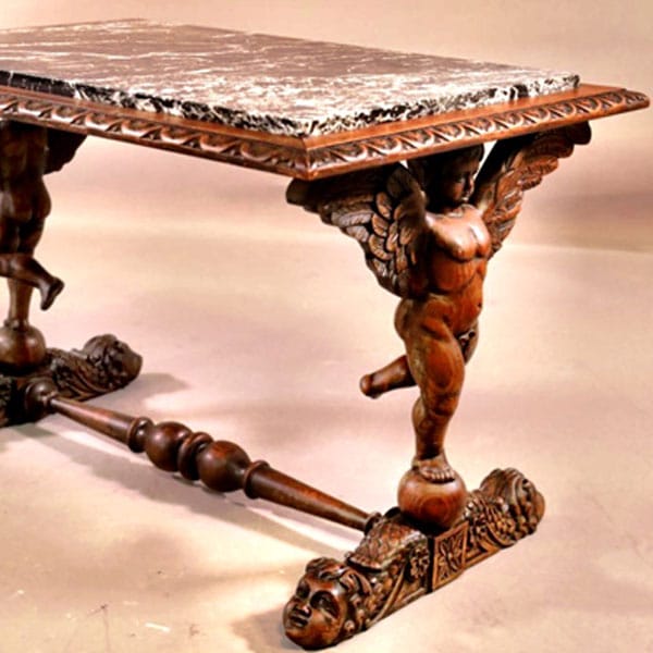wood carved table with cupid base and marble top.